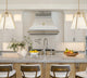 Curved Stainless Steel Range Hood with Fleur-de-Lis and Brass Pot Rack