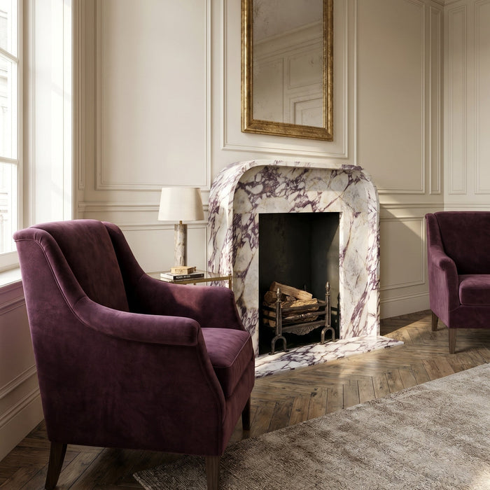 Luxurious living room with purple armchairs and a marble fireplace.